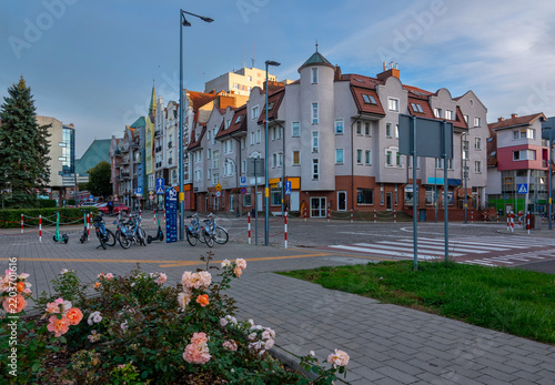 Colorful residential buildings and a street view with a flower bed in Kolobrzeg, Poland