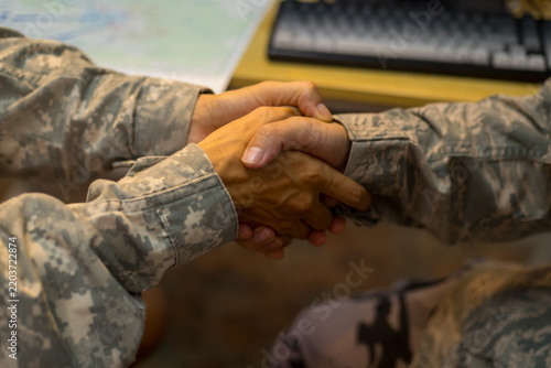 Experienced military hands focused intensely around a tactical map table, actively collaborating and planning precise strategic operations, operational logistics