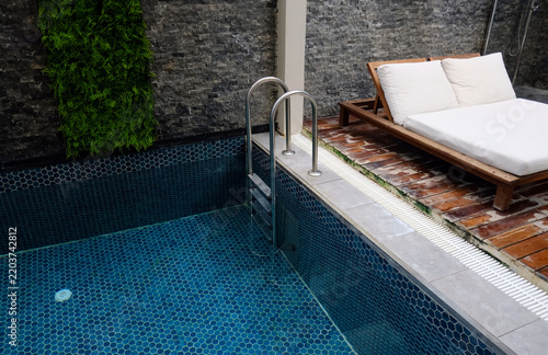 Clean modern pool with blue mosaic tiles and stainless ladder, showing a well-maintained swimming pool interior and water surface.