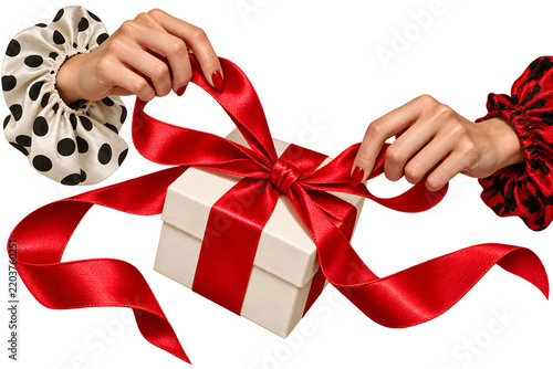 Manicured female hand holding an object isolated on white background with elegant red nails and modern beauty styling.