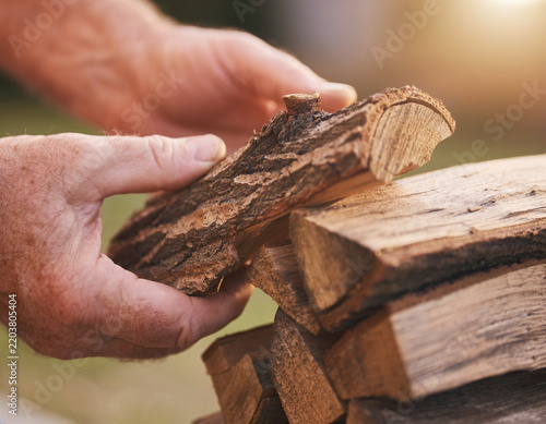 Hands stacking firewood logs outdoors