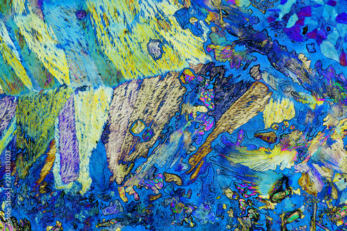 Polarized light microscopy of organic acid mixture showing mosaic crystal blocks and abstract vibrant structures under cross polarization optical microscope for chemistry science background