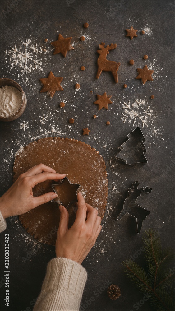 Obraz premium Hands cut star shapes from gingerbread dough with a cookie cutter on a flour-dusted table. Christmas baking and festive food preparation. Homemade holiday treats and seasonal cooking.