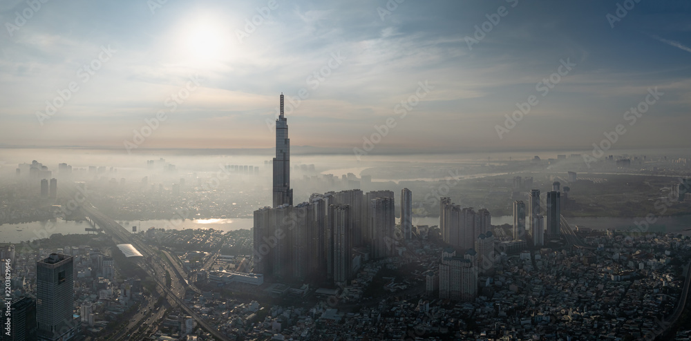 Fototapeta premium Landmark 81 and city towers silhouetted in bright haze, Ho Chi Minh City, Vietnam