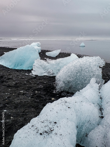 Obraz na płótnie Black-sand beach in Iceland, known as Diamond Beach, famed for the glistening fragments of broken icebergs drifted ashore from Jökulsárlón - Glacial River Lagoon
