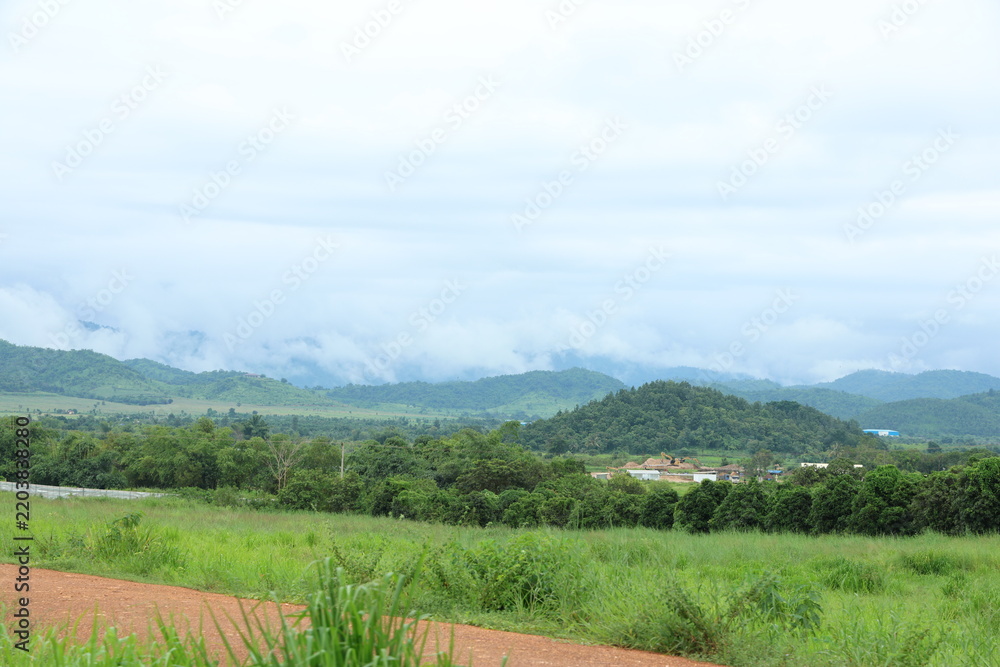 Fototapeta premium Green hills and mountains under cloudy sky