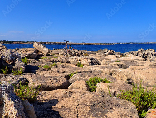 Bicicletta sulla costa rocciosa di Ognina di fronte al mare, Siracusa, Sicilia 640