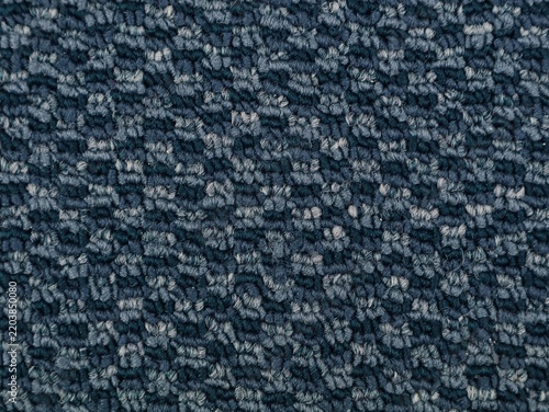 High resolution close up shot of a dark blue patterned carpet texture. Ideal for interior design backgrounds, flooring material samples, architectural details, and textile pattern wallpapers