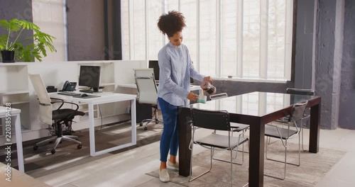 Businesswoman enjoying coffee break standing in modern office with natural light