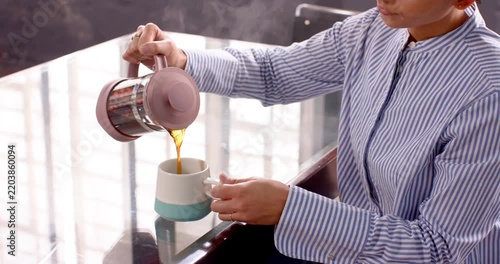 Businesswoman enjoying coffee break at office, smiling and relaxing at desk