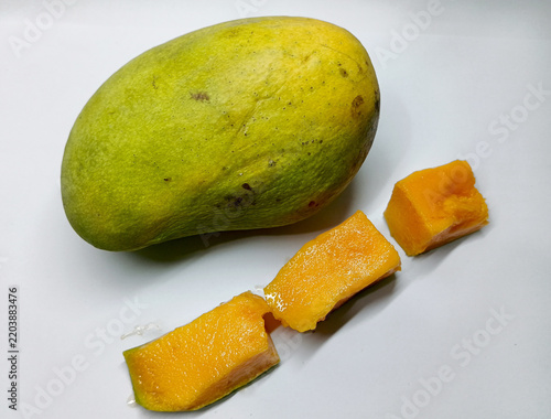 Whole Ripe Mango with Fresh Juicy Mango Slices on White Background