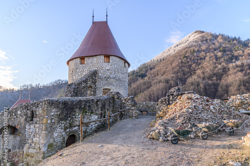 Фотография Round keep of Žovnek Castle above ruined walls with restoration works under way,