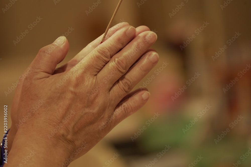Obraz premium Person holding joss sticks praying