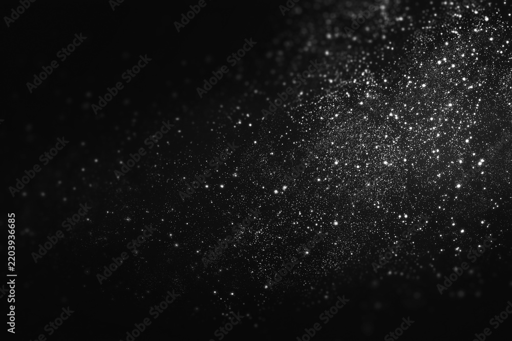 Obraz premium Silver glitter particles on a dark background. Christmas Abstract monochrome shimmering dust texture with bokeh. Galaxy or magical shimmering dust.