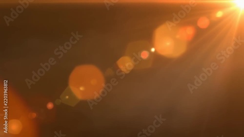 Golden lens flare bursts and bokeh lights in cinematic motion with warm orange glow
