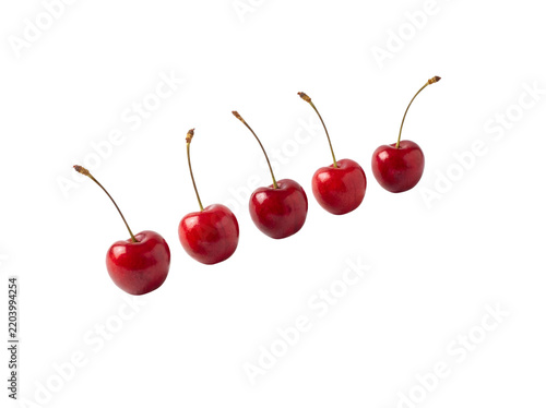 Five fresh red cherries arranged in a row