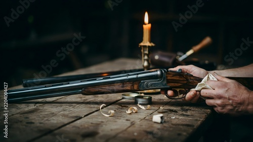 Traditional wooden rifle resting on rustic wooden table with person handling it