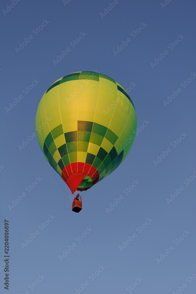 Obraz premium Colorful hot air balloon floats high against a deep blue sky with copy space. Leisure flight represents adventure, aspiration, freedom and discovery from above.