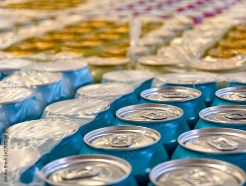 Obraz na plátne Blue and yellow cans filled with carbonated beverages are stored in packaging at