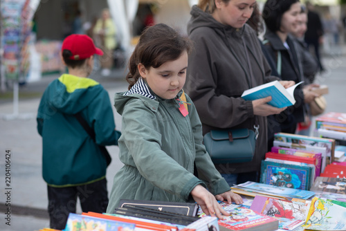 A young girl with a backpack at a book fair