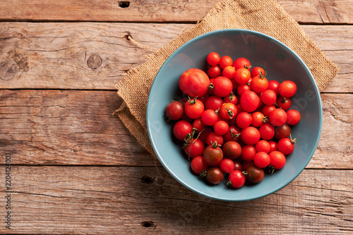 Fresh Cherry Tomatoes in a Blue Bowl on a Wooden Table
