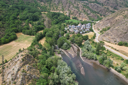 Aerial view of traditional catalan mountain village Borén and Borén reservoir on sunny summer day. Lleida, Catalonia, Spain.