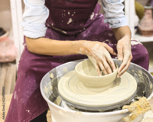 Creative afro american young woman molding clay on pottery wheel. Workshop in ceramic studio