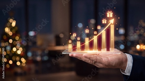 Hand Holding Glowing Bar Graph with Gift Icons Showing Upward Trend 
