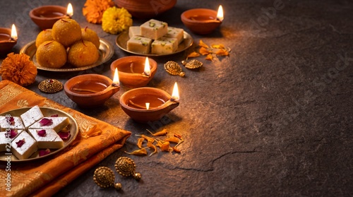 Diya oil lamps and Indian sweets for Diwali festival celebration
