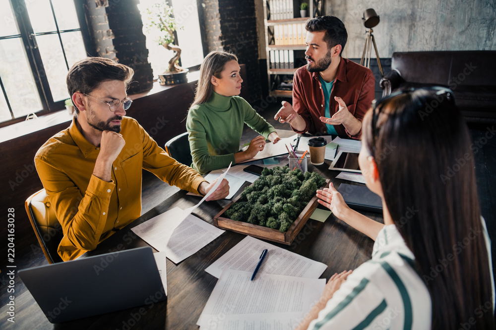 Obraz premium Young creative team discussing sustainable urban landscape model and project plans during a collaborative business meeting in a modern loft office workspace