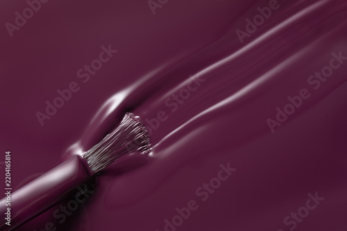Burgundy nail polish stroke with brush close up