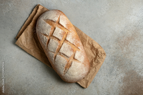 Loaf of artisanal sourdough bread on grey textured background