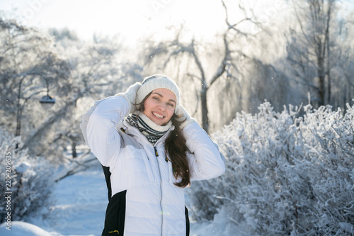 Young smiling woman standing in snowy winter forest