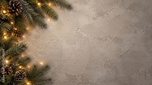 Decorative Pine Branches With Lights and Pine Cones on a Textured Surface
