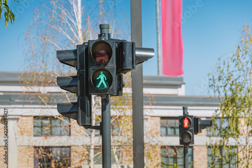 Pedestrian crossing signal illuminating a green walking figure, indicating safety and permission to cross in an urban environment