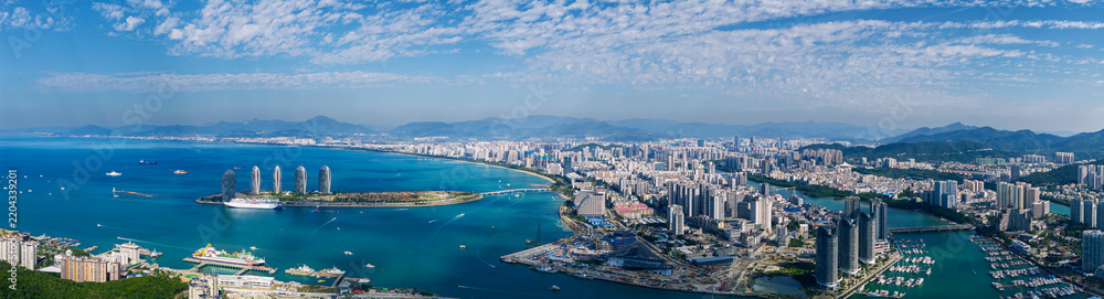 Fototapeta premium Coastal city skyline spanning curved bay aerial panorama
