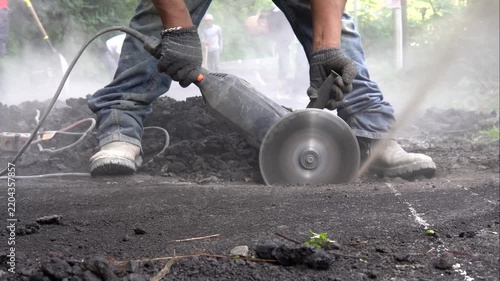Industrial cutting machine cutting asphalt roofing felt at a construction site