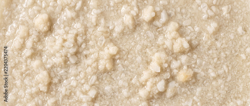 Wet struvite precipitate appearing as pale moist agglomerates with soft mineral clusters and uneven slurry-like texture