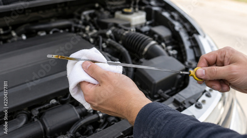 Mano comprobando nivel de aceite mediante varilla automotriz