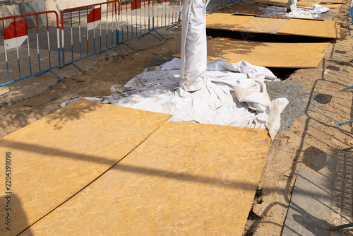 Картината върху платно Plywood panels covering pavement around a white wrapped pole beside metal crowd