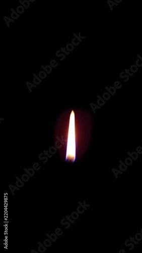 Vertical Single Candle Flame Burning on Isolated Black Background