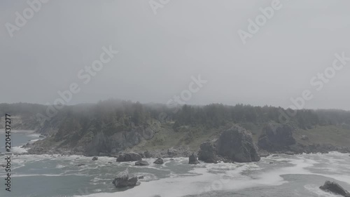 Misty coastal sea stacks rising from ocean water