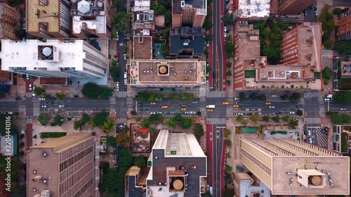 Flow of cars with yellow taxis in moves by the long straight streets along the high-rise buildings. Top view on the neighborhood of modern New York City, USA from drone.