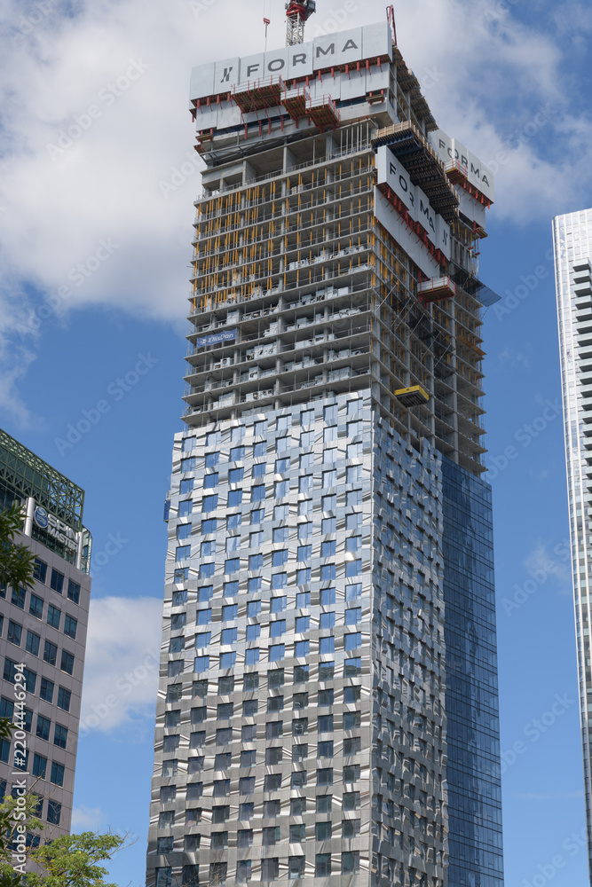Obraz premium Forma East Tower, a residential and retail/commercial structure, designed by Frank Gehry, featuring rippling stainless-steel panel facade, located at 266 King St W, Toronto