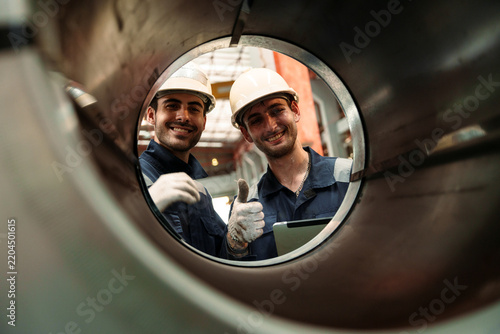 Engineers and staff are inspecting the assembly line system in a metal sheet and metal roofing manufacturing plant.