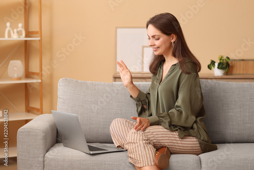 Remote work and video conferencing, woman waving hello during a virtual meeti...
