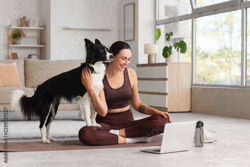 Work-life balance and remote work, woman practicing yoga with her dog while u...