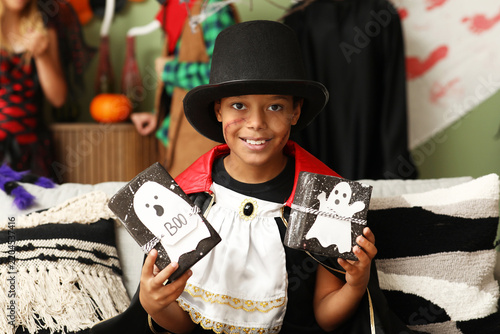 Cute happy African-American boy dressed as Dracula for Halloween party with g...