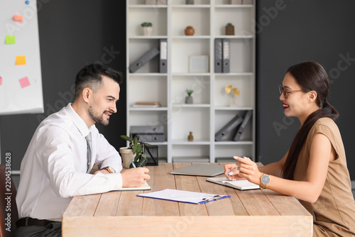 Human resources manager interviewing male applicant in office