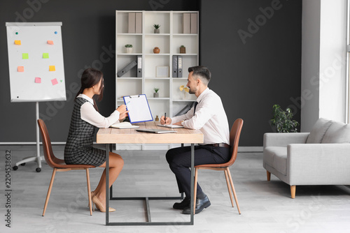 Human resources manager interviewing applicant at table in office